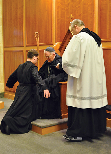 The abbot, or superior of the monastery, cinches a belt around the waist of Brother Thomas Jones, O.S.B. as he is clothed with the tunic for the first time. The tunic and the belt are the most basic pieces of the monastic habit, which a man receives as he enters the monastery.